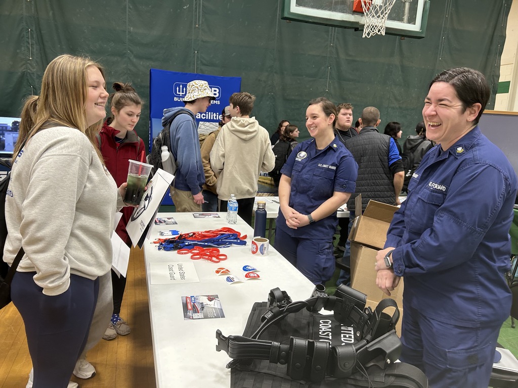 two coast guard representatives laughing with students