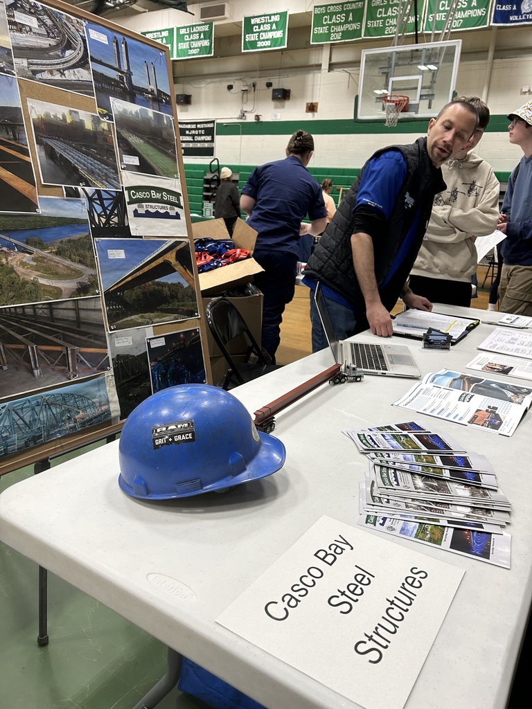 a construction hat on a table with a sign that says casco bay steel structures